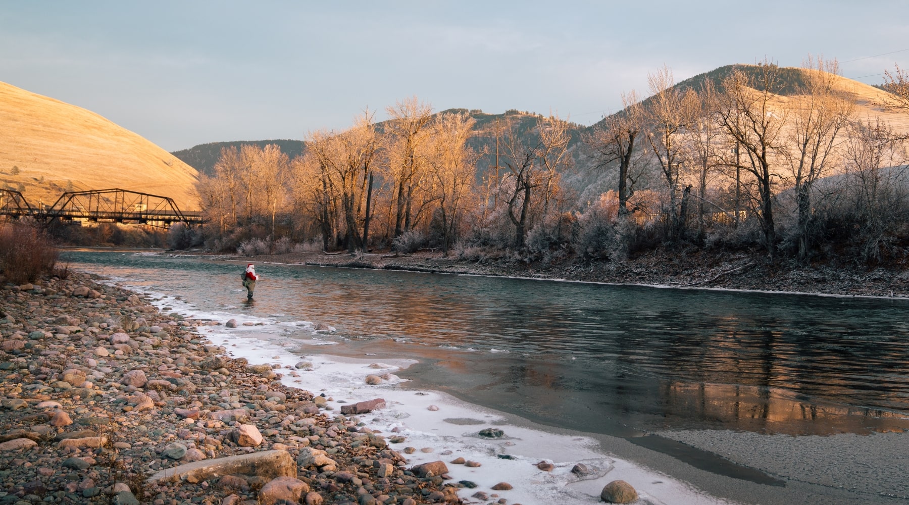 an angler dressed as santa claus fly fishing in a river