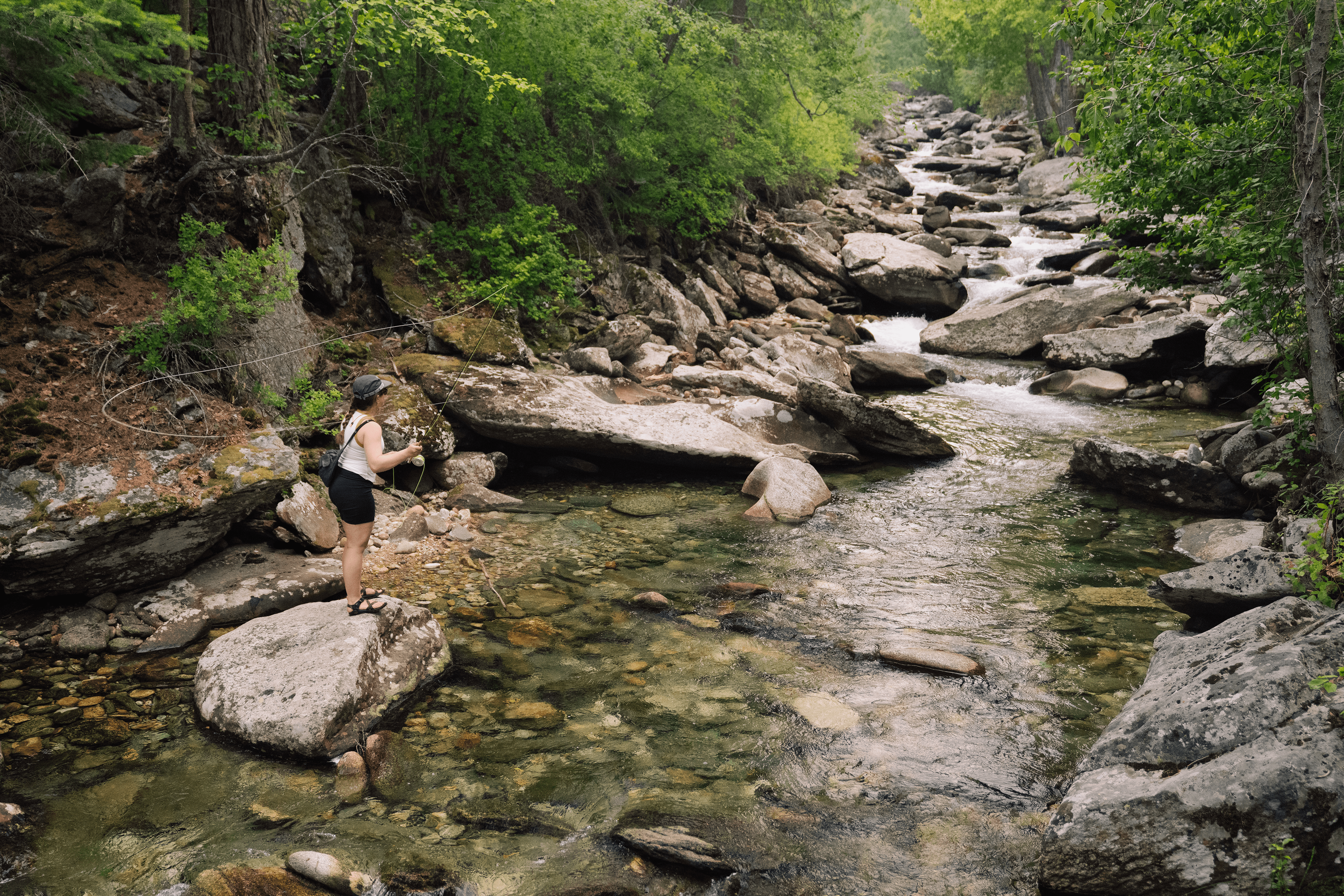 a woman fly fishing on a creek in Montana
