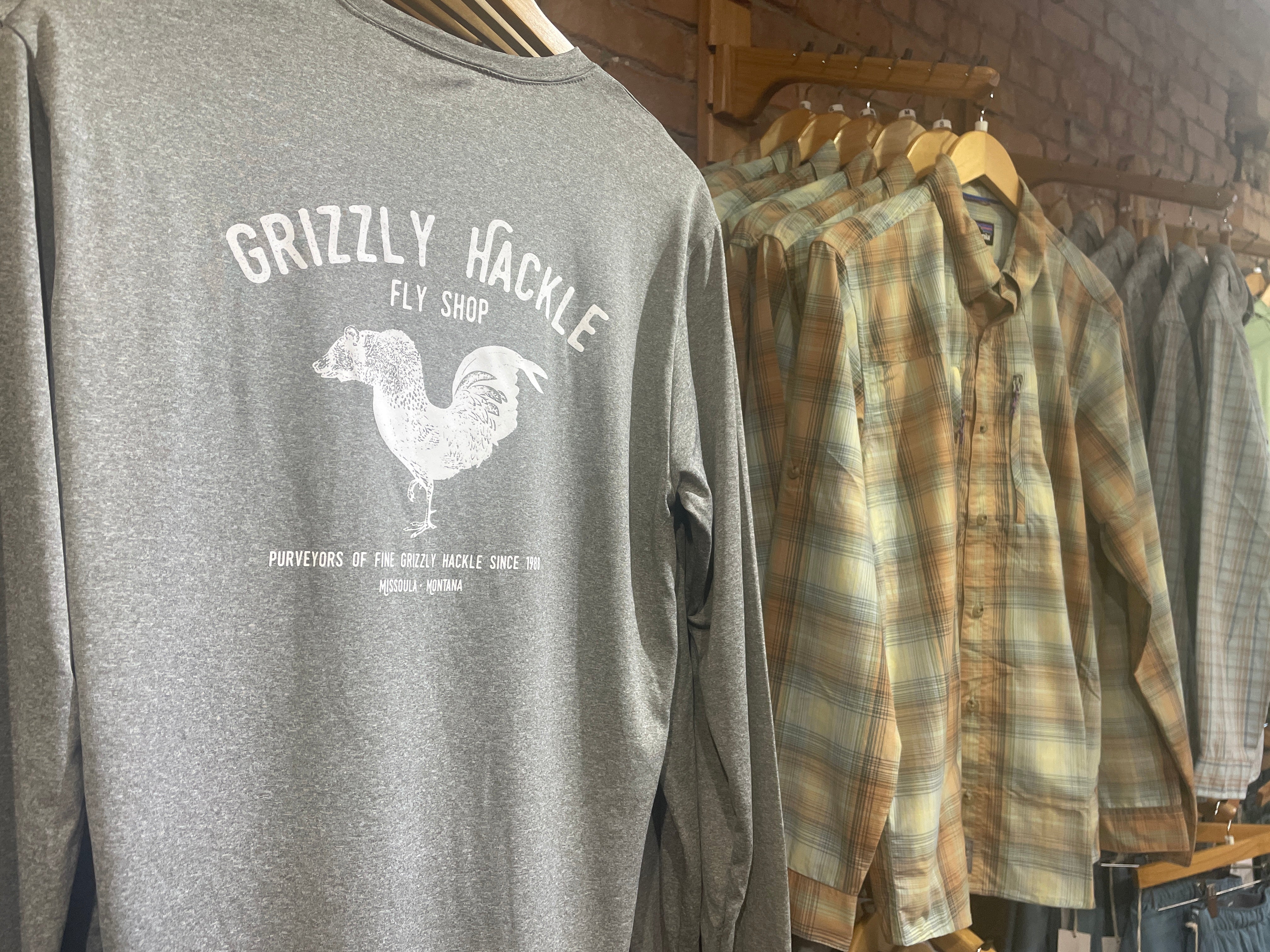 a gray shirt and a tan collared shirt hung on a rack