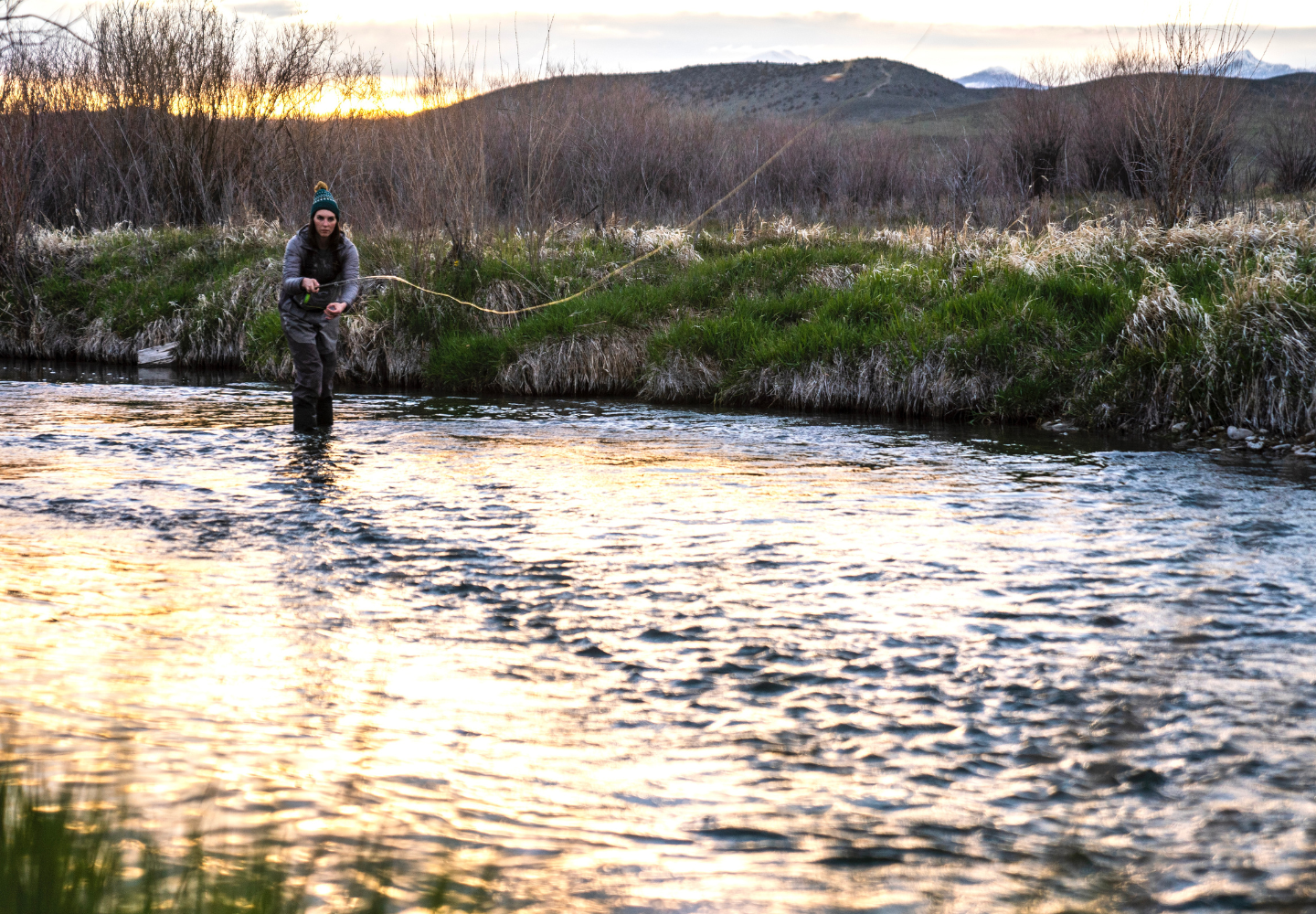 Fly angler casts fly downstream while fly fishing for trout