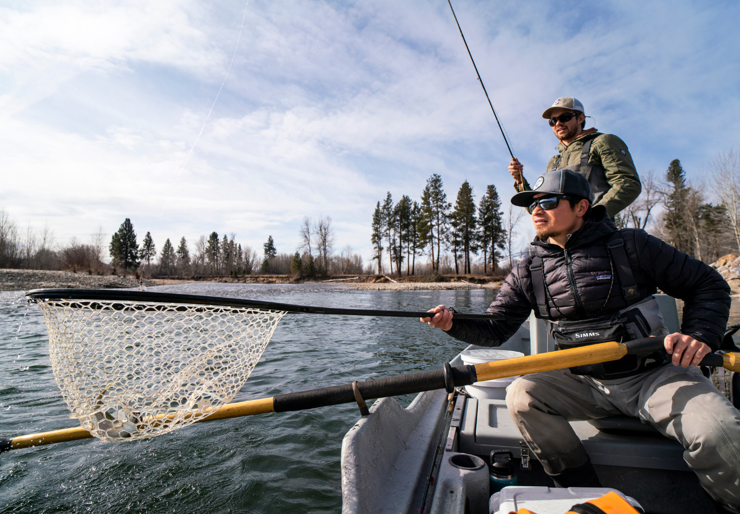 two fly fishermen net a trout while fly fishing in Montana